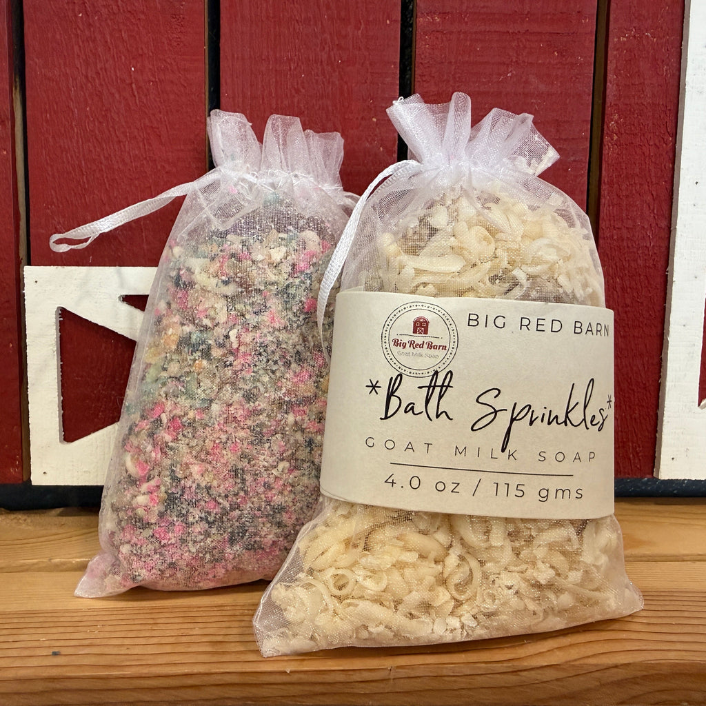 Two bags of Big Red Barn Bath Sprinkles goat milk soap in front of a red barn-like background.