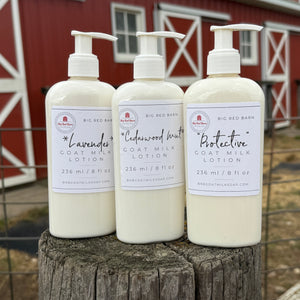 Three bottles of coat milk lotion on a wooden post with a red barn in the background
