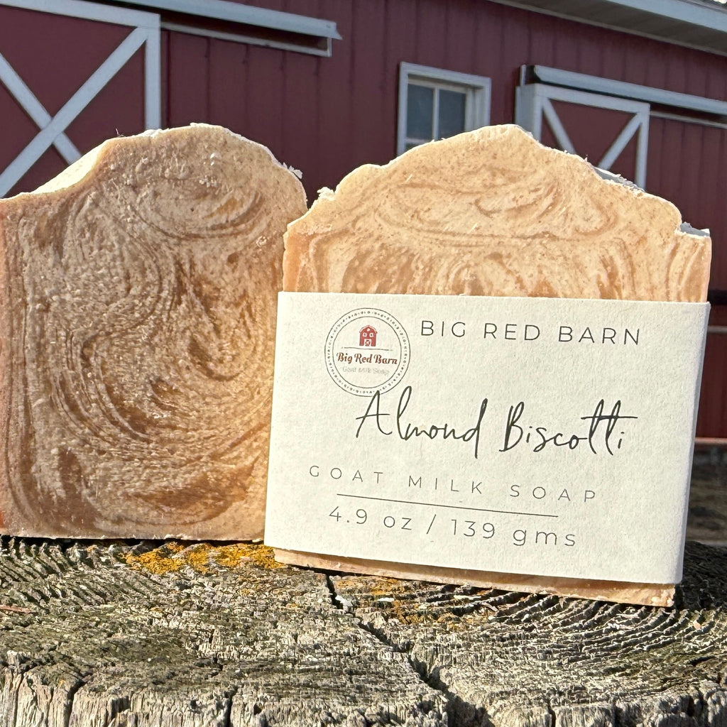 Goat milk soap bar with a label in front of a red barn.