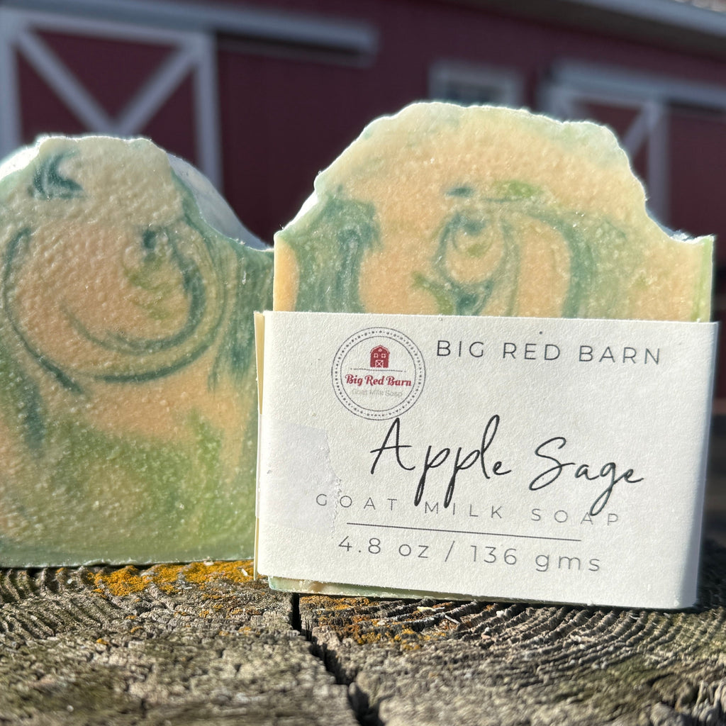 Two bars of Apple Sage goat milk soap with a Big Red Barn label on a wooden surface.