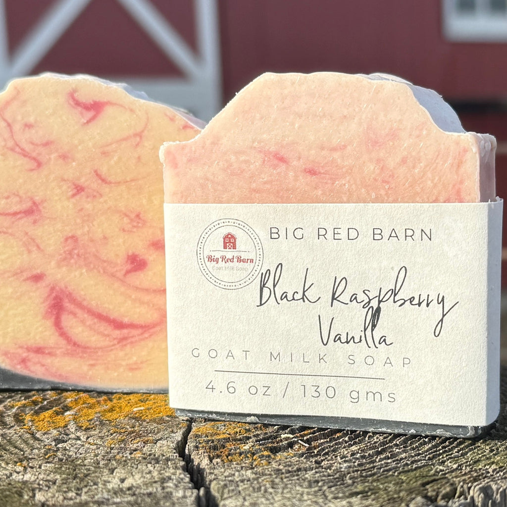 Bar of soap with a visible label on a wooden surface, with a red barn in the background.