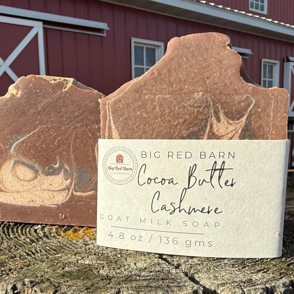 Two bars of soap with a label in front of a red barn.