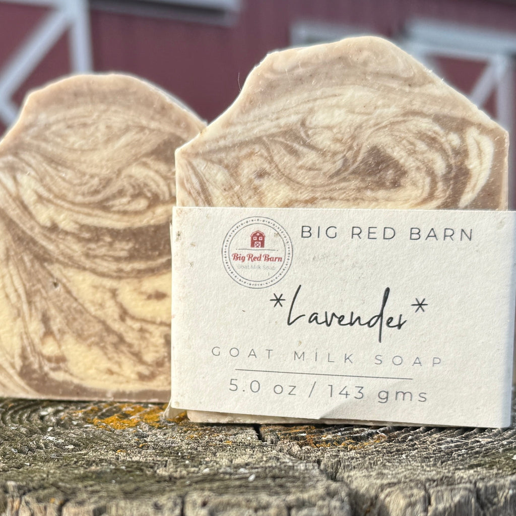 Two blocks of goat milk soap with a Big Red Barn label on a wooden surface.